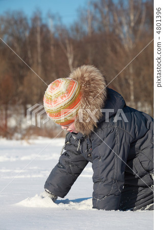 little boy crawls in snow on nature at winter, white snow, trees little boy crawls in snow on nature at winter, white snow, trees 4801396