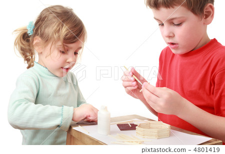 little girl and boy in red T-shirt crafts at small table, keenne 4801419