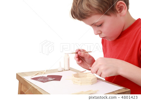 little boy in red T-shirt crafts at small table, glue, side view little boy in red T-shirt crafts at small table, glue, side view 4801423