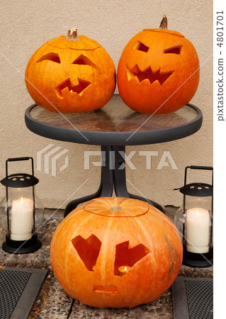 Three pumpkins of Halloween. Two lie on glass little table. One 4801701