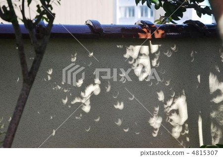 The shadow of a solar eclipse that has become crescent-shaped with sunlight through sunlight 4815307