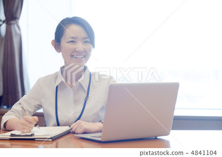 A woman working on a laptop while laughing at the window of backlight A woman working on a laptop while laughing at the window of backlight 4841104