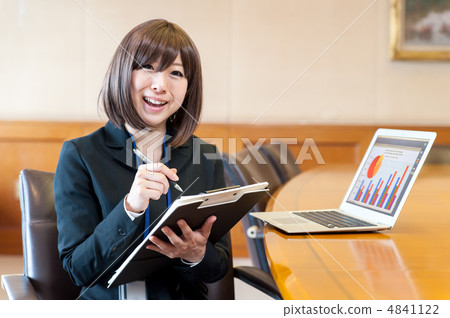 拿著文件和一支筆在便攜式計算機前面和談話的婦女笑 4841122