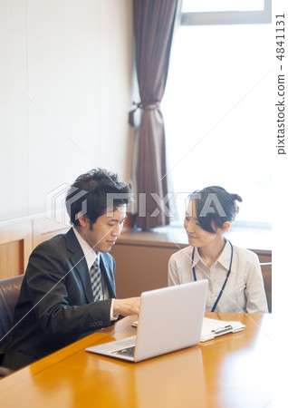 一名男性受薪男子和一名女子在材料面前與一台筆記本電腦交談 4841131