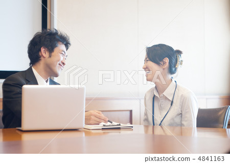 A male salaried man and a woman who talks with a laptop computer in front of materials A male salaried man and a woman who talks with a laptop computer in front of materials 4841163
