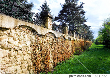 Fence placed a long brick wall. Fence placed a long brick wall. 4841483