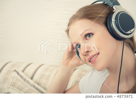 beautiful girl enjoys listening to music on headphones on the so 4873971