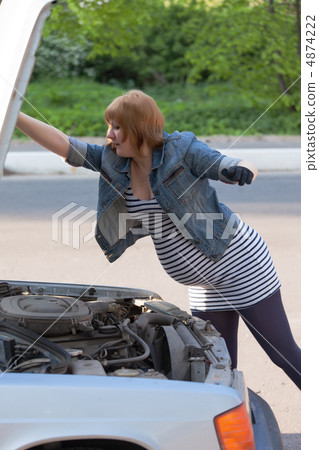 Pregnant Woman Opens the Hood of the Car Pregnant Woman Opens the Hood of the Car 4874222