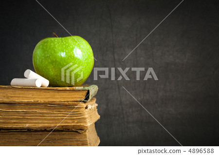 Green apple and chalk on old books Green apple and chalk on old books 4896588