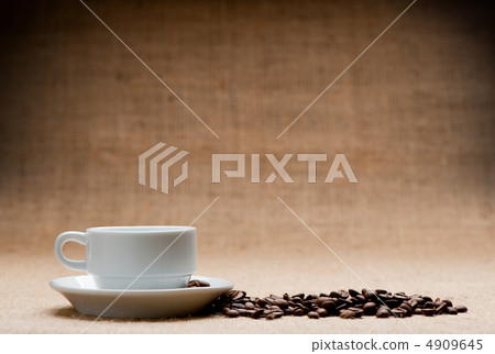 White cup c grains of coffee on grunge a background White cup c grains of coffee on grunge a background 4909645