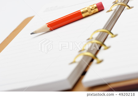 Open notebook with copper binding and red pencil. Open notebook with copper binding and red pencil. 4920218