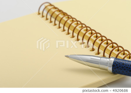 Pen and a notebook on a spiral with a yellow paper Pen and a notebook on a spiral with a yellow paper 4920686