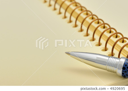Pen and a notebook on a spiral with a yellow paper Pen and a notebook on a spiral with a yellow paper 4920695