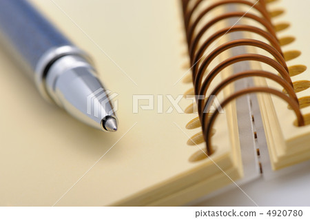 Pen and a notebook on a spiral with a yellow paper Pen and a notebook on a spiral with a yellow paper 4920780