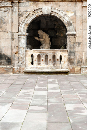 Monument praying elder in a cave 4920990