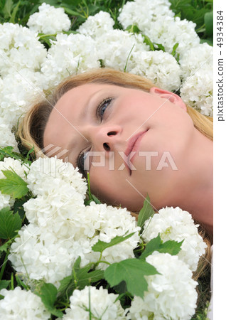 Young woman laying in flowers - snowballs 4934384