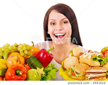 Woman choosing between fruit and hamburger. 4941628