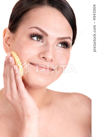 Young woman washing her face by sponge. Young woman washing her face by sponge. 4943004