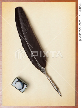Feather quill and inkwell on an old paper 4956056
