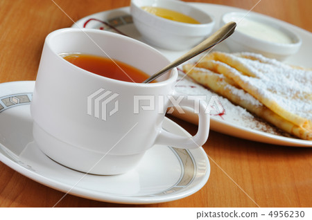 Tea and pancakes with powdered sugar Tea and pancakes with powdered sugar 4956230