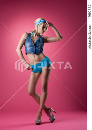 Sexy go-go dancer in jeans on pink background 4960582