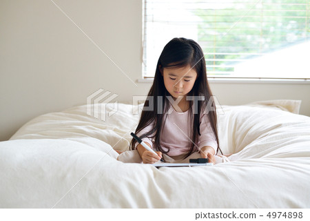 Elementary school student writing a message on the bed 4974898