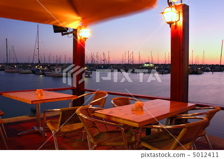 Outdoor restaurant on marina at evening. 5012411