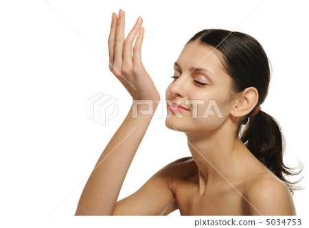 The pretty woman enjoying aroma of perfume. It is isolated on a The pretty woman enjoying aroma of perfume. It is isolated on a 5034753