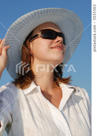The woman in glasses and a hat on a background of the sky The woman in glasses and a hat on a background of the sky 5035563