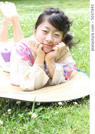 A girl lying on the lawn in a yukata A girl lying on the lawn in a yukata 5037843