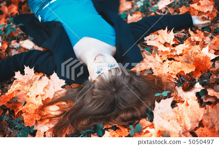 Girl Lying in Autumn Leaves 5050497