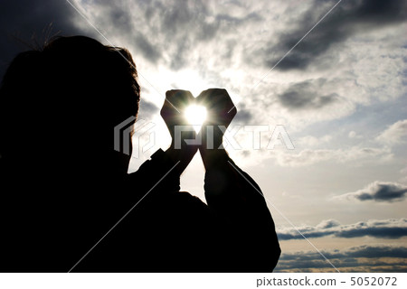 man holding a sun in his hands against the sky 5052072