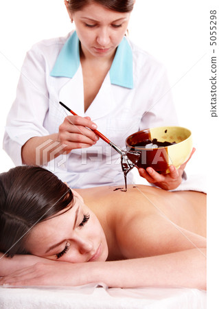Girl having chocolate  mask apply by beautician. 5055298