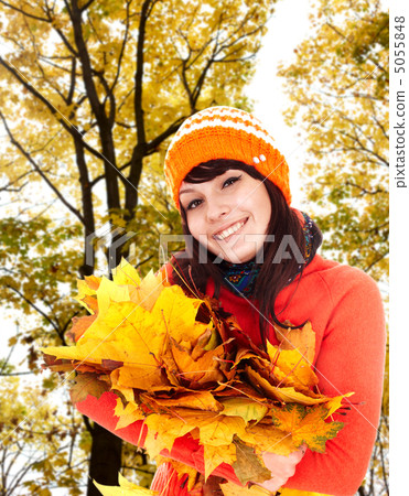 Girl in autumn orange hat with leaf group near tree. 5055848