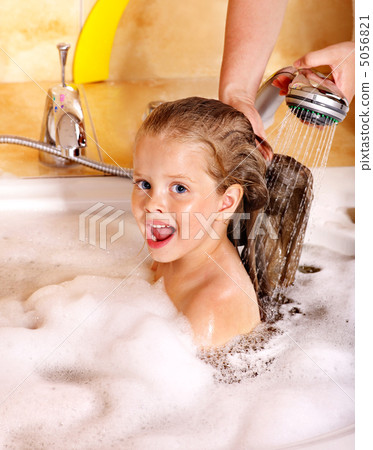 Kid washing hair by shampoo . 5056821