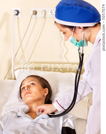 Doctor treats patient with stethoscope. 5057074