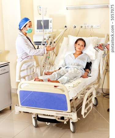 Doctor treats patient with defibrillator. 5057075