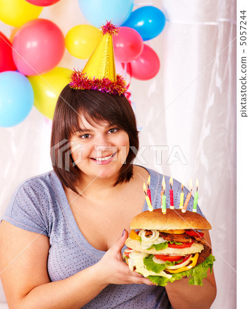 Woman eating hamburger at birthday. Woman eating hamburger at birthday. 5057244