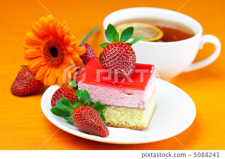 gerbera, lemon tea, cake and strawberries lying on the orange fa gerbera, lemon tea, cake and strawberries lying on the orange fa 5088241