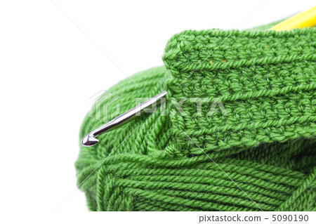 Skein of wool, crochet hook  and knitted piece isolated on white 5090190