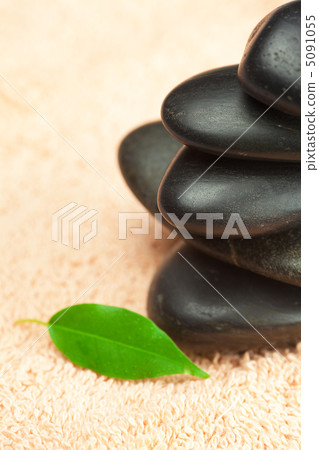 black spa stones  with green leaf and a drop of water on the tow 5091055
