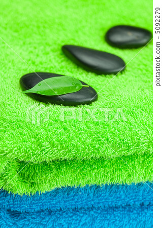 black spa stones lying on the towel black spa stones lying on the towel 5092279