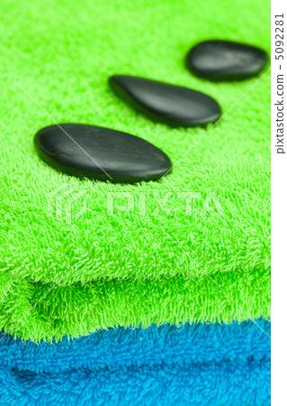 black spa stones lying on the towel black spa stones lying on the towel 5092281