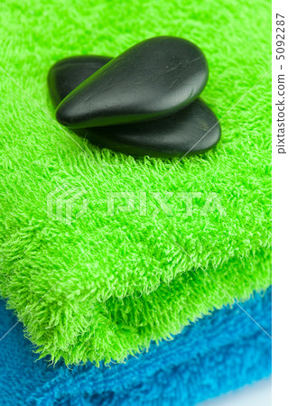 black spa stones lying on the towel black spa stones lying on the towel 5092287