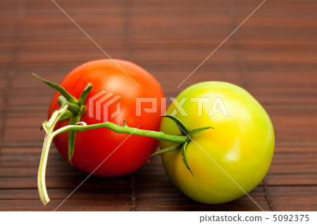 red and green tomatoes on a bamboo mat red and green tomatoes on a bamboo mat 5092375