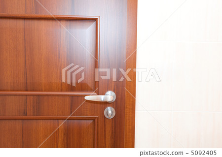 wooden door with a handle in a white room 5092405