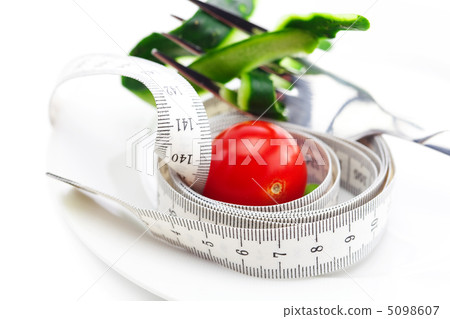 tomato,fork ,cucumber skin and measure tape on a plate isolated tomato,fork ,cucumber skin and measure tape on a plate isolated 5098607