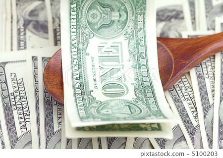 Dollars in the wooden spoon on dollars background 5100203