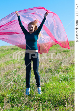 young beautiful woman jumping with tissue into the field against young beautiful woman jumping with tissue into the field against 5111324