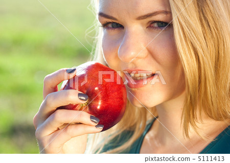 portrait of a beautiful young woman with apple  outdoor 5111413